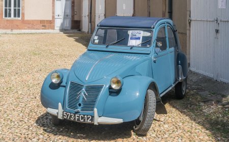 A classic Citroën 2CV with a canvas roof and rounded bonnet.